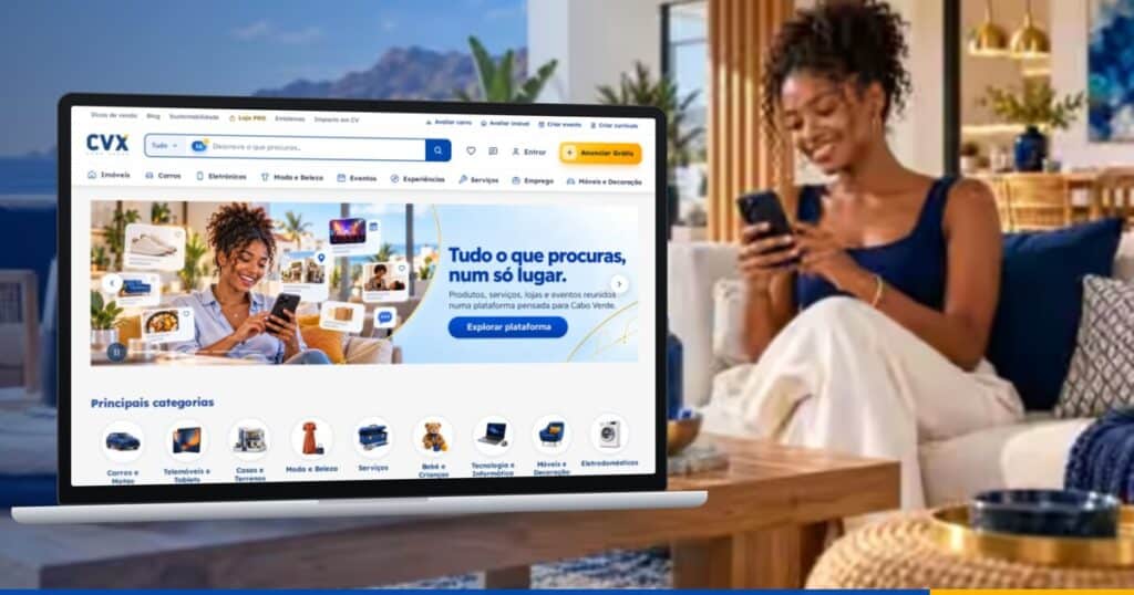 Portátil com a página inicial da CVX aberta, numa sala com vista para o mar, enquanto uma mulher usa o telemóvel no sofá